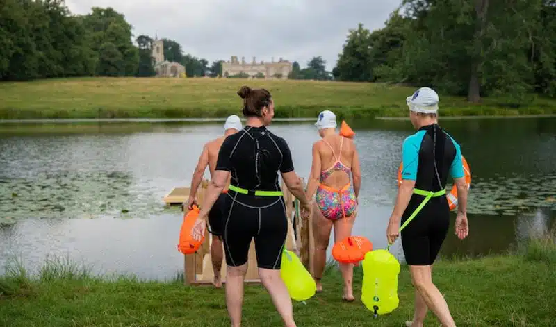 A group of swimmers about to enter the lake at the Falcon, Castle Ashby