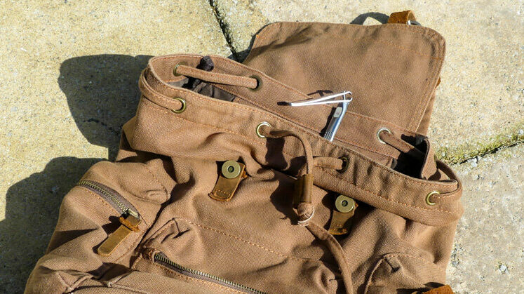 Une paire de coupe-ongles sur un sac à dos qui sera utilisé comme bagage à main.