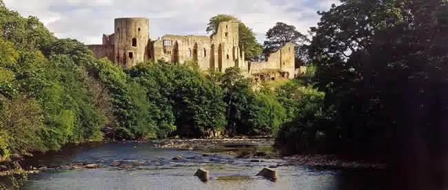 view of the castle at barnard castle from the river tees