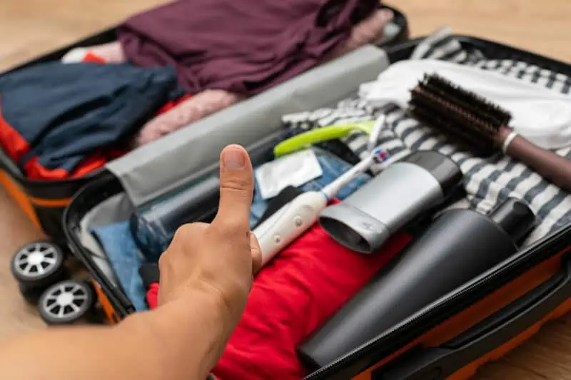 Traveler suitcase full of clothes at cozy modern apartment