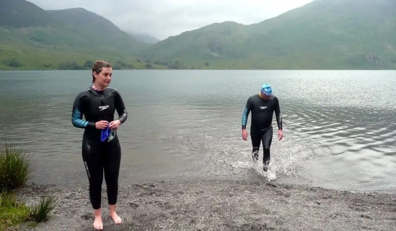 Two outdoor swimmers finishing a swim in Crummock Water in the Lake DIstrict