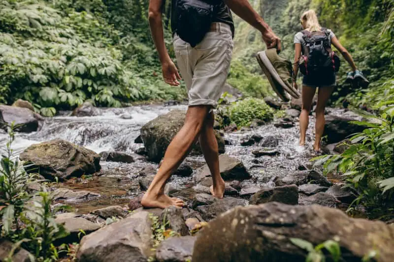 walking barefoot up a stream in a valley